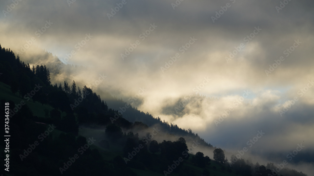 Obraz premium sunrise with dark clouds and sunlight over the mountains