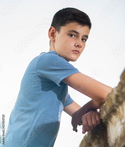 Adolescente posado sobre una vigeta