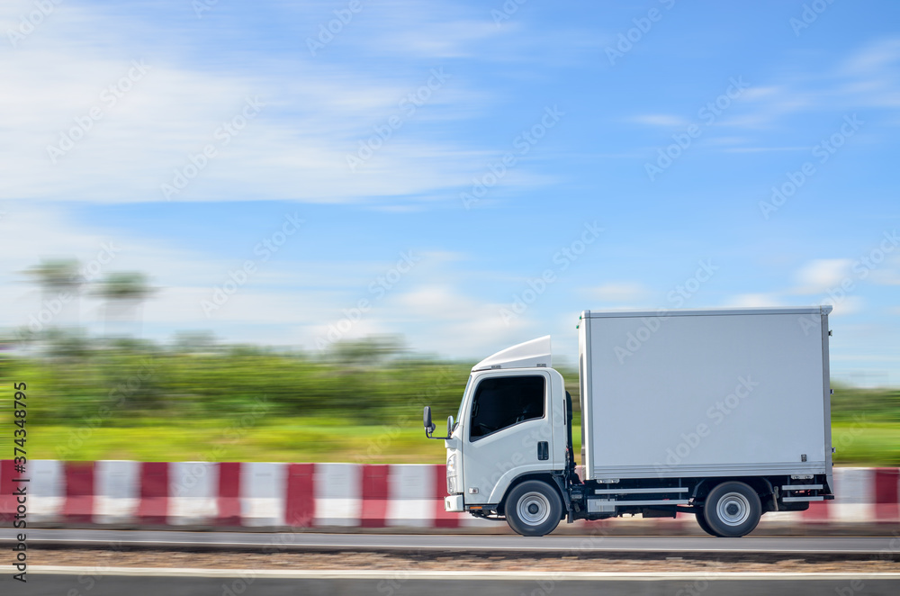 Deliver a small white truck moving on a green natural path against a blue sky background.