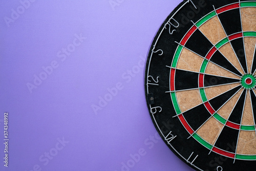 target dart board on the purple table background, center point, head to target marketing and business success concept