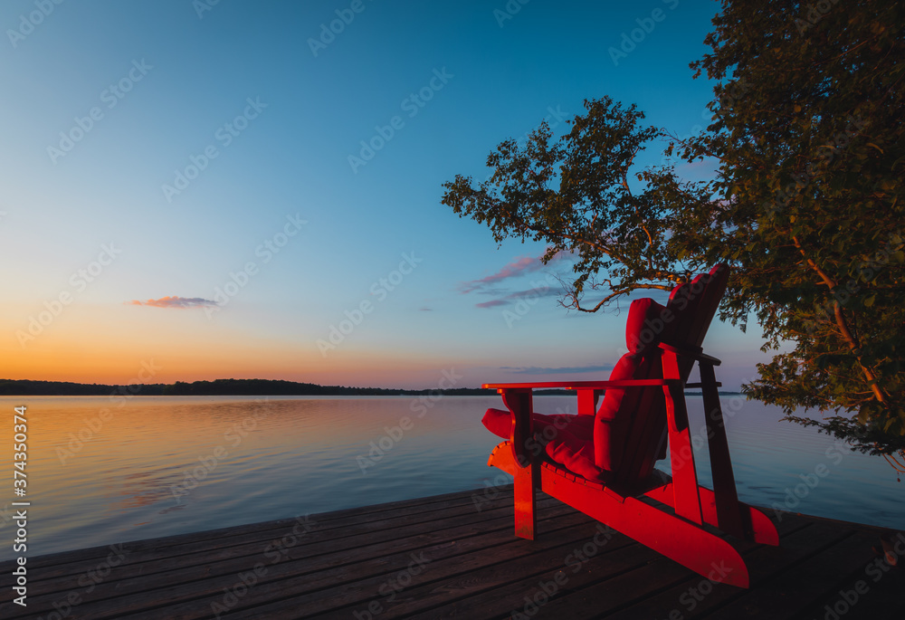 Muskoka chair on dock at sunset
