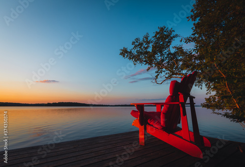 Obraz na płótnie Muskoka chair on dock at sunset w salonie