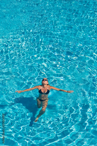 woman in luxury spa resort near the swimming pool.