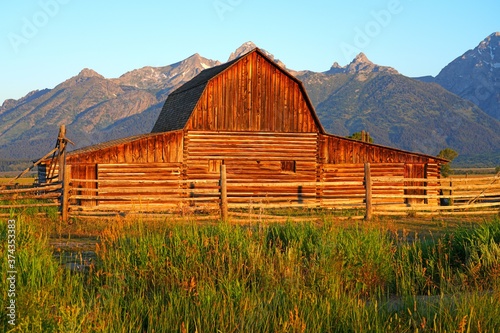 Sunrise over a log cabin on Mormon Row Historic District in Antelope Flats in Grand Teton National Park in Wyoming, United States