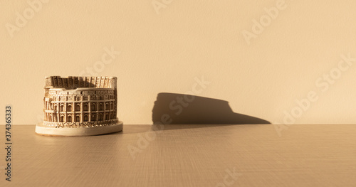 Tableau sur toile coliseum on a wooden table with his shadow