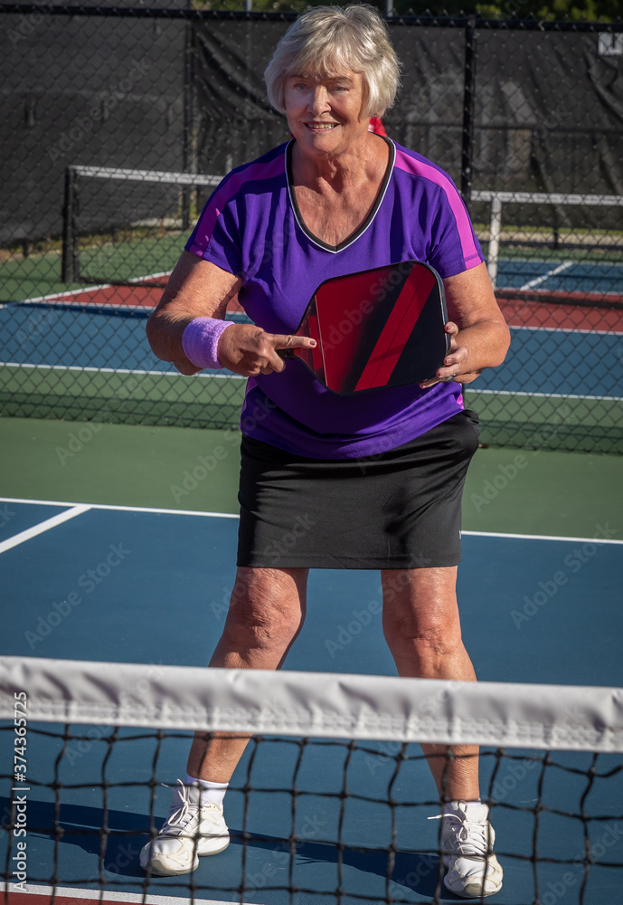 Woman holds her pickleball paddle ready for a volley Woman holds her pickleball paddle ready for a volley