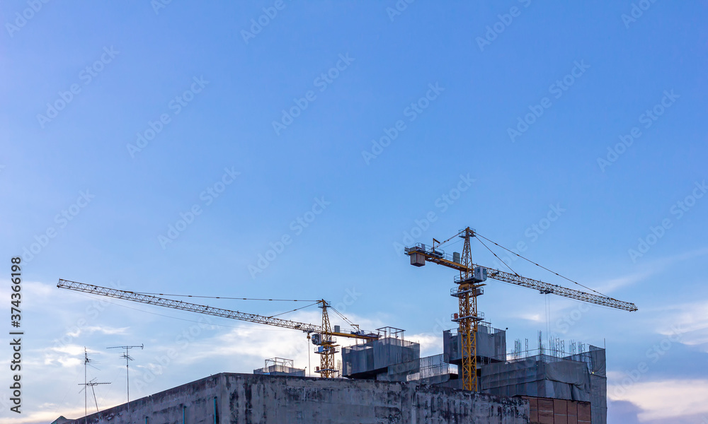 A huge crane at hotel or condo building construction site with blue sky