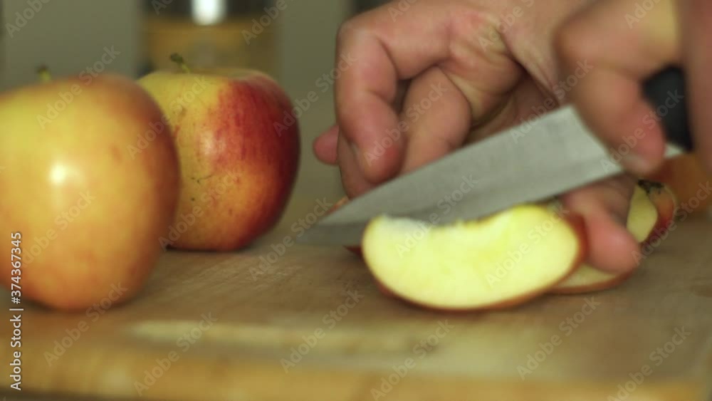 Man's hand slicing apple with knife