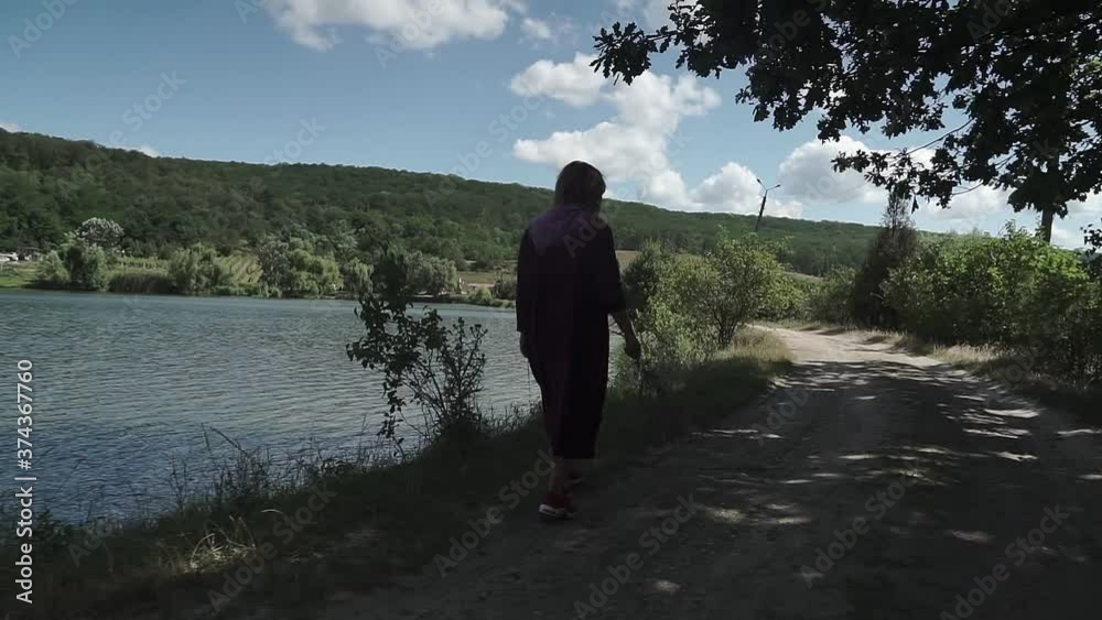 Women in long dress walks along the lake shore. A walk in the fresh air. Women in long dress walks along the lake shore. A walk in the fresh air.
