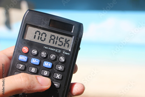 Word No risk on napkin and calculator on wooden tble . Finance concept photo