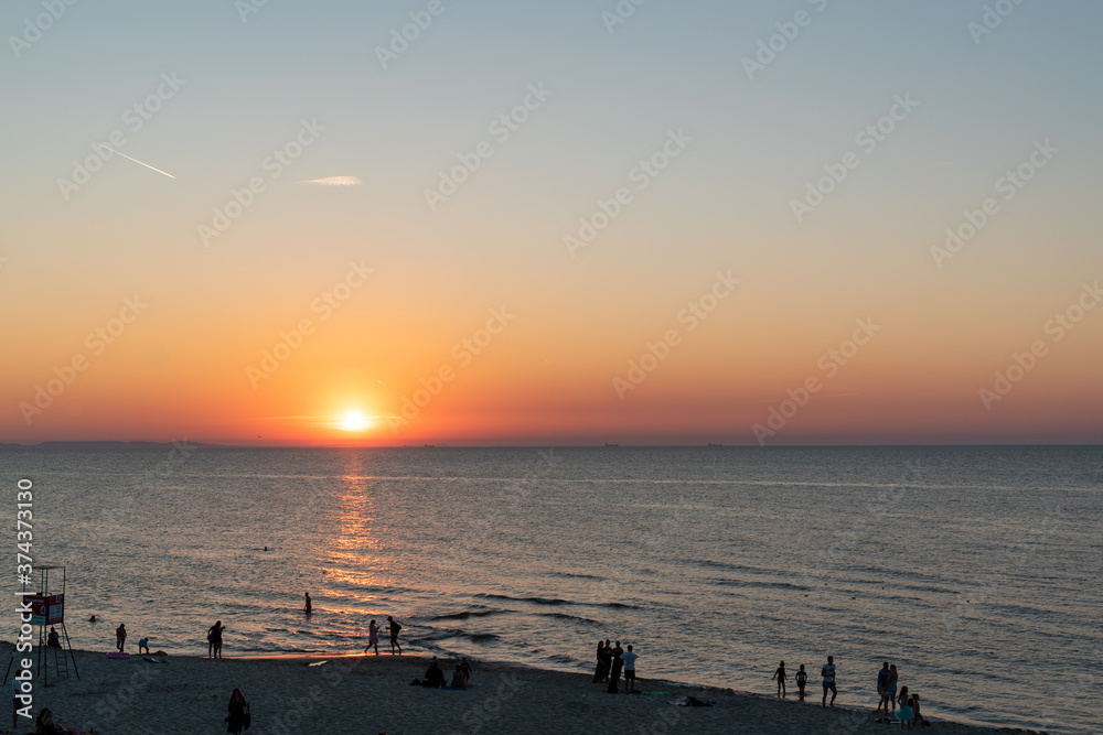 silhouette of many people enjoying a sunset on the Baltic Sea in Poland
