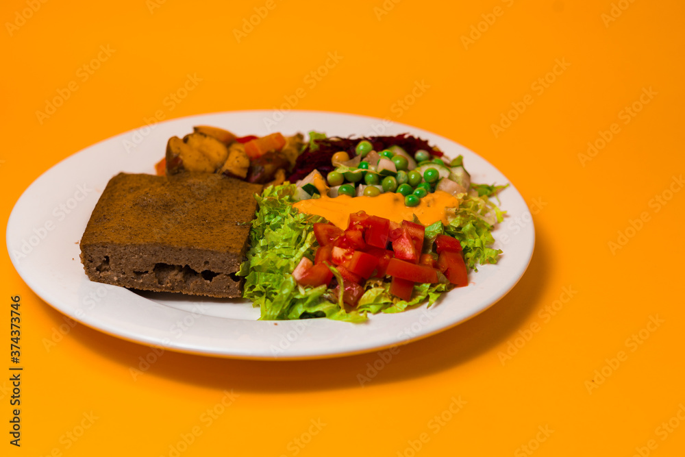 Vegan baked tortilla salad on a round plate yellow background
Vegan baked tortilla salad on a round plate yellow background
