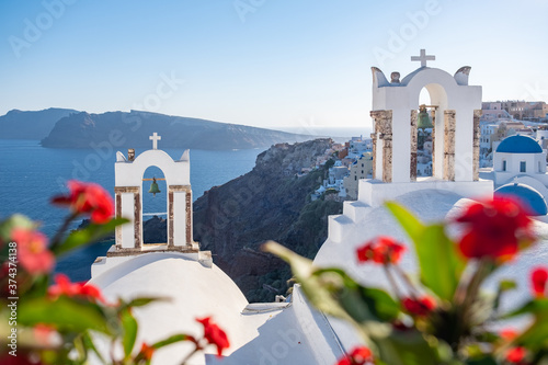 Sunset at the Island Of Santorini Greece, beautiful whitewashed village Oia with church and windmill during sunset, streets of Oia Santorini during summer vacation at the Greek Island photo