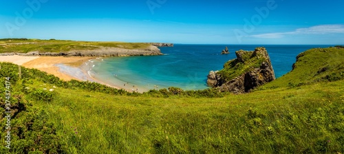 Broad Haven beach and Church Rock viewed from a grassy bank on the Pembrokeshire coast, Wales in early summer