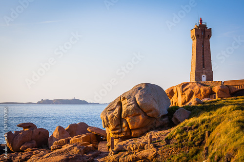 Old lighthouse at the Cote de Granit Rose at the coast of Brittnay, France photo