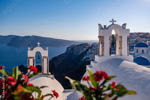 Sunset at the Island Of Santorini Greece, beautiful whitewashed village Oia with church and windmill during sunset, streets of Oia Santorini during summer vacation at the Greek Island photo