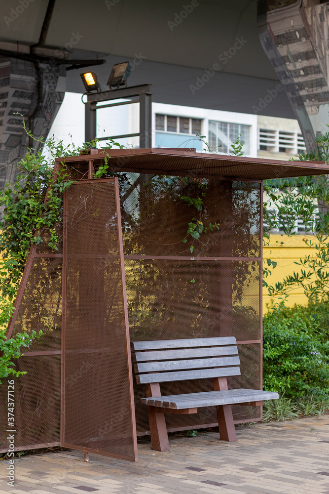 Wooden bench with metal mesh shelter in park Wooden bench with metal mesh shelter in park