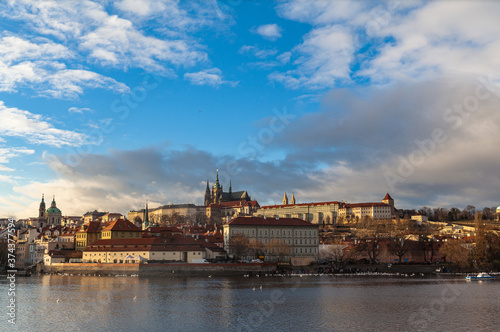 Beautiful view of Mala Strana old district of Prague on the Vltava river side with Wallenstein Palace, Prague Castle and St. Nicholas Church, on sunny winter day with blue sky cloud, Czech Republic