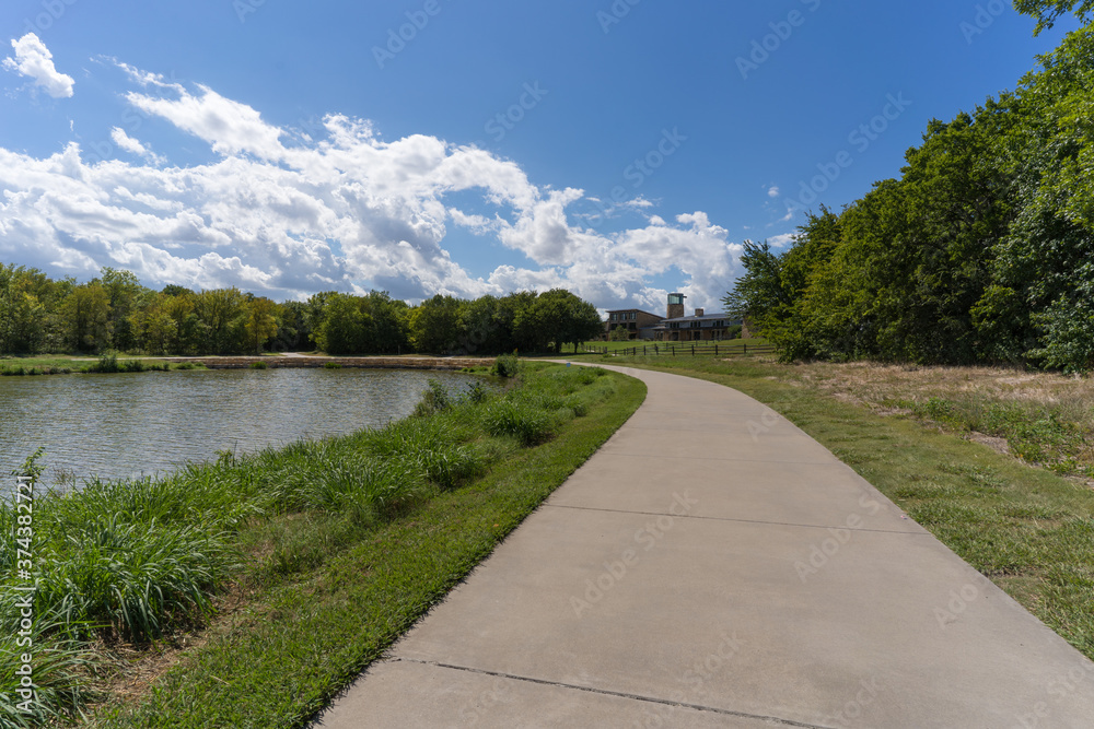 A concrete path in a Texas city park on a sunny August day.