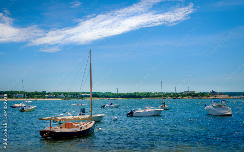 Seascape with moored boats at bay on blue sky with white clouds backgrounds