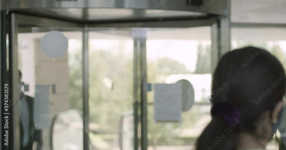Business people arriving in corporate office lobby wearing protective face mask, receptionist giving them directions Business people arriving in corporate office lobby wearing protective face mask, receptionist giving them directions