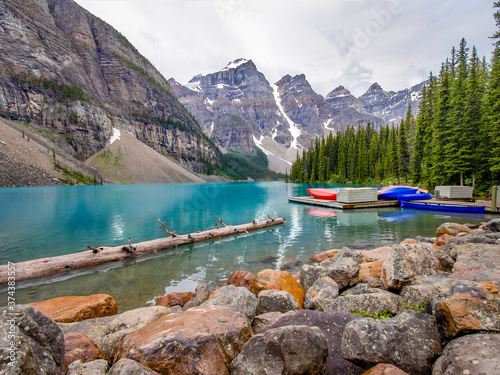 Beautiful Canadian famous turquoise Moraine Lake, Banff National Park, AB. The view on the valley of the ten peaks. The rocks in the foreground, canoe pier and forest in the middleground.