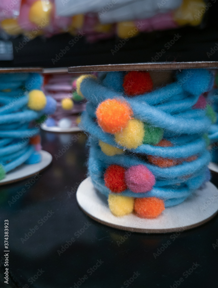 blurry decorative fluffy colored threads with multicolored balls close up

