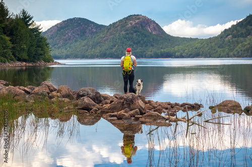 Female hiker and dog at Jordan Pond and The Bubbles, Acadia National Park, Maine photo