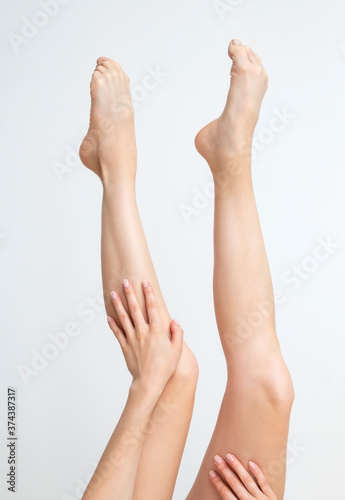 Perfect clean female feet . Beautiful and elegant groomed girl hand touches her feet . Spa  scrub and foot care .