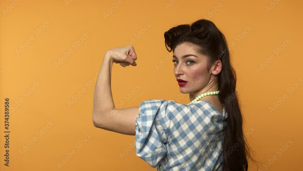 Strong pin up girl showing biceps and smiling at camera