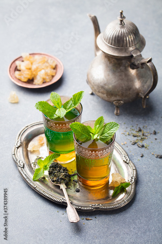 Mint, green tea in glass. Moroccan traditional drink. Grey background.
