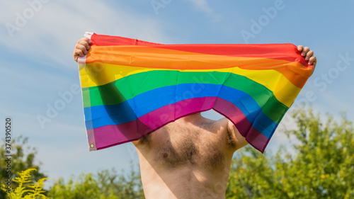 a half-naked man spreading the LGBT flag