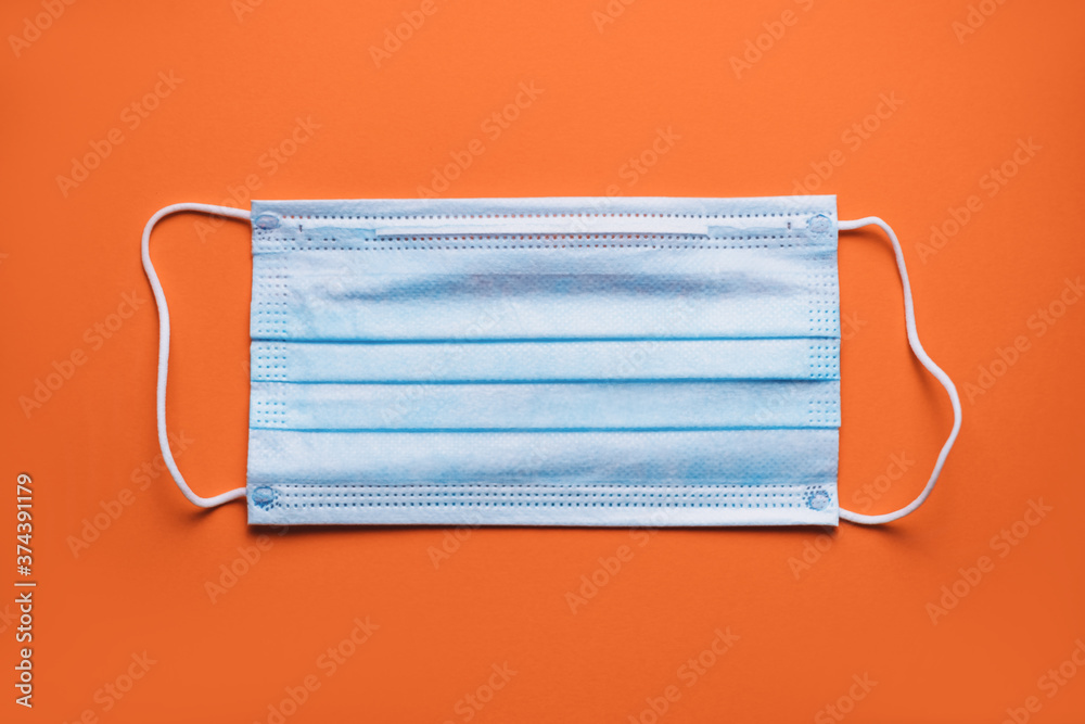 Medical protective mask isolated on orange background. Medical mask protection against pollution, virus, flu, coughing and coronavirus. Medical protective mask isolated on orange background. Medical mask protection against pollution, virus, flu, coughing and coronavirus.