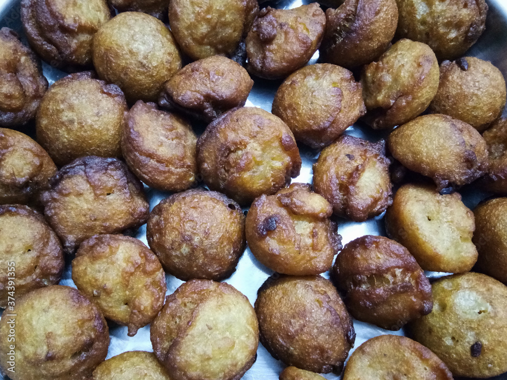 Kerala traditional style soft puffy sweet unni appam placed in a steel plate after being fried in hot boiled coconut oil Kerala traditional style soft puffy sweet unni appam placed in a steel plate after being fried in hot boiled coconut oil