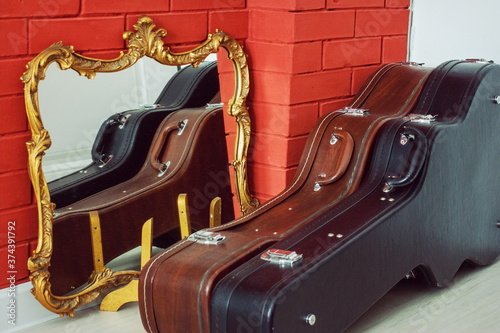 Guitar cases near the mirror and fireplace
