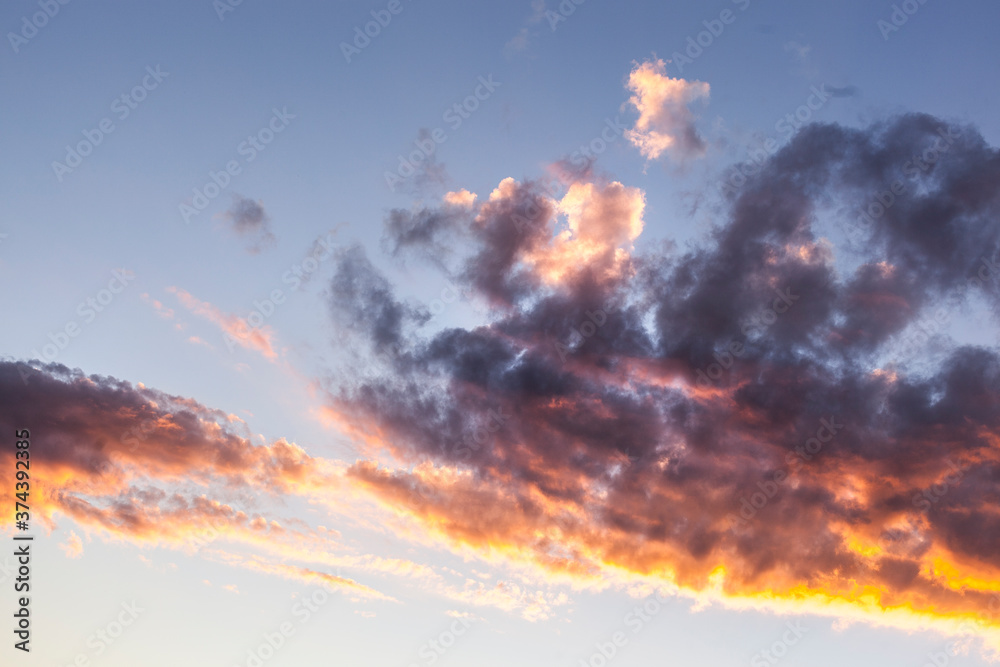 Fototapeta premium Clouds at sunset against blue sky. Wolken bei Sonnenuntergang vor blauem Himmel.