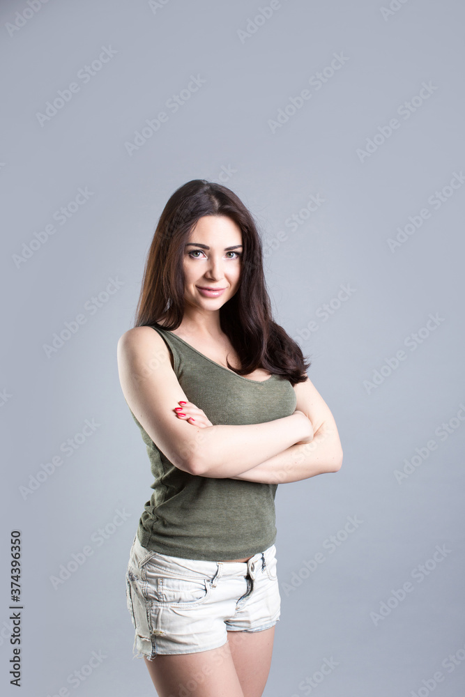 Studio portrait of smiling brunette woman over gray background. Studio portrait of smiling brunette woman over gray background.