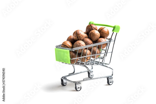 Miniature cart from the supermarket. A cart full of nuts. A lot of Macadamia isolated on a white background.