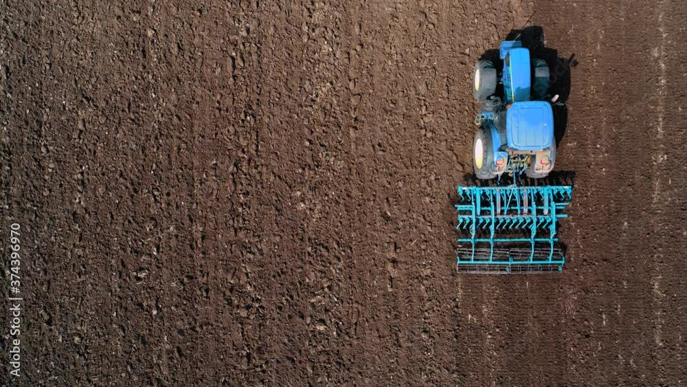 Tractor plowing the agricutural fields, aerial view