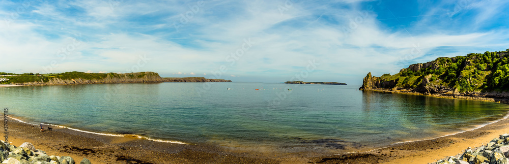 The circular bay of Lydstep Haven, Wales with Caldey Island in the distance in early summer The circular bay of Lydstep Haven, Wales with Caldey Island in the distance in early summer