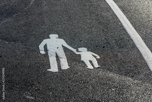Fototapeta Naklejka Na Ścianę i Meble -  Painted symbol on the asphalt marking a walking path.