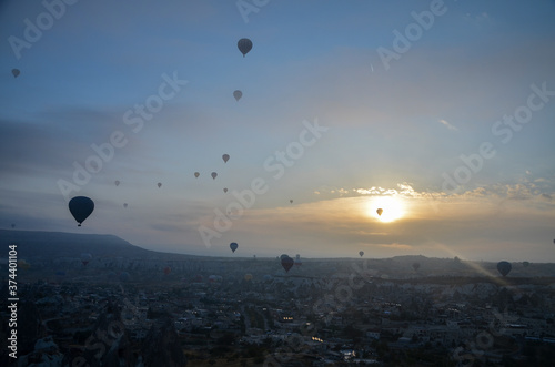 Colorful hot air balloons flying over mountains landscape and the valley at Cappadocia in the sunrise sky at foggy morning