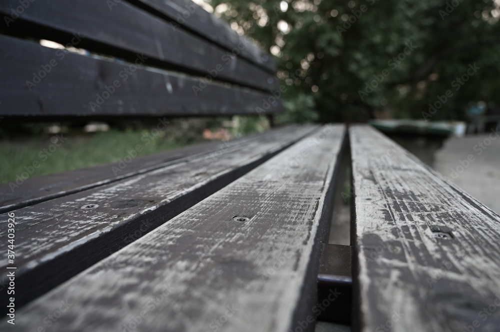 Perspective view of shabby planks of an old painted bench in a public park. Perspective view of shabby planks of an old painted bench in a public park.