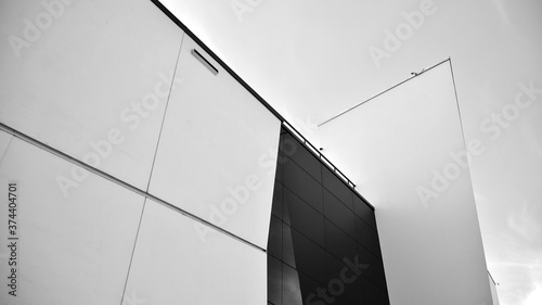 Modern office building wall made of steel and glass with blue sky. Black and white.