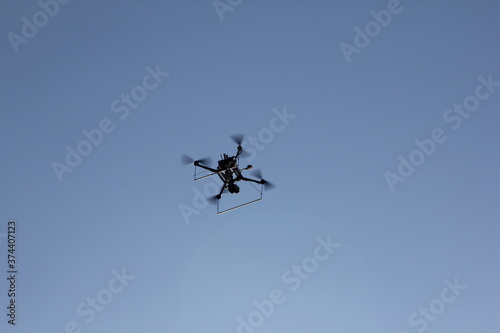 Flying handmade drone on blue sky background