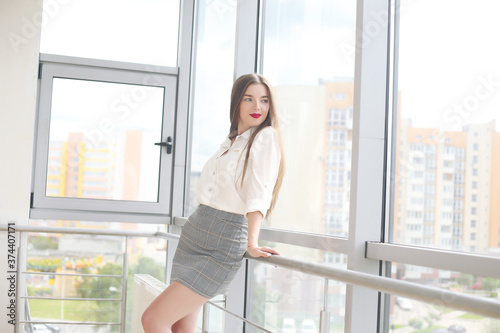 Happy businesswoman leaning on desk in office, office europe