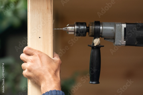 Closeup view of man drilling wooden support