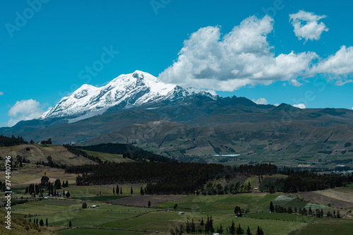 cayambe volcano with a amazing blue sky over green agricultural fields on ecuador 