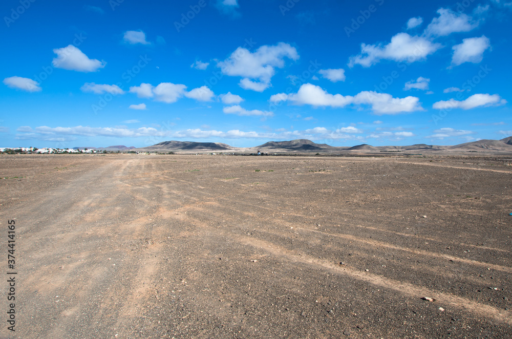 desert landscape of the hinterland of Fuerteventura arid volcanic island.Blue and cloudy sky of Canary Islands