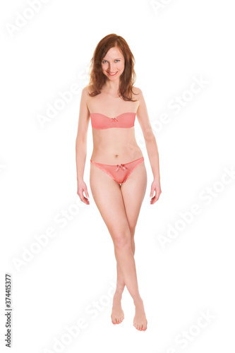 Full length portrait of an attractive woman wearing red bra and panties, isolated in front of white studio background